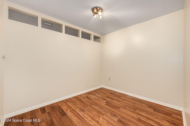 empty room with hardwood / wood-style flooring and a textured ceiling