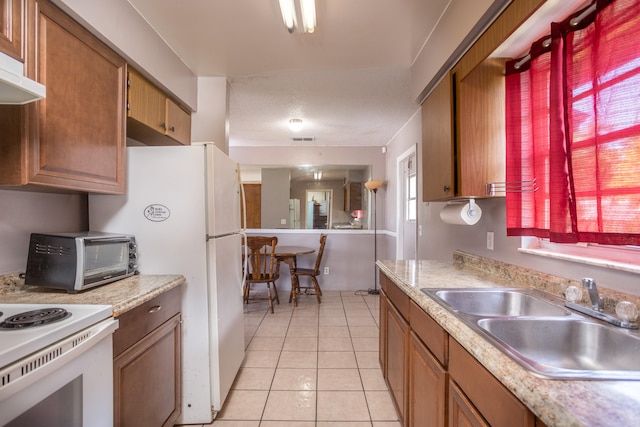 kitchen featuring light tile patterned flooring, white appliances, and sink