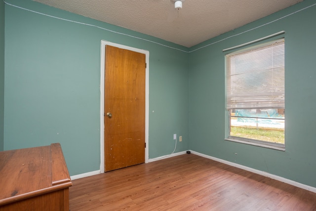 unfurnished bedroom with hardwood / wood-style flooring and a textured ceiling