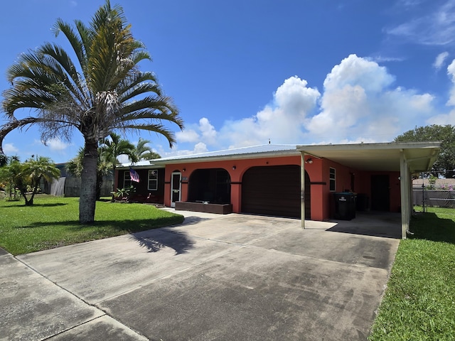 view of front of property with a carport, a garage, and a front yard