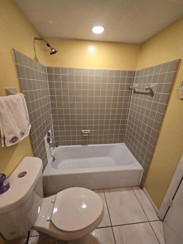 bathroom with tile patterned flooring, tiled shower / bath combo, and toilet