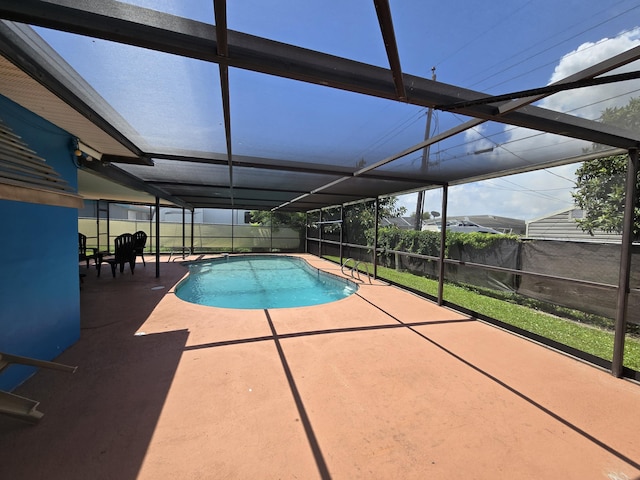 view of swimming pool featuring a patio and a lanai