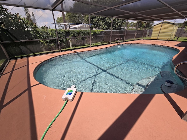 view of swimming pool featuring a storage unit, a lanai, and a patio