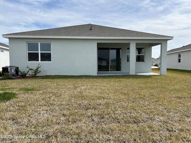 back of property with a yard and central AC unit