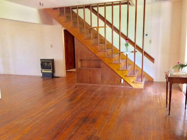 staircase featuring hardwood / wood-style flooring and heating unit