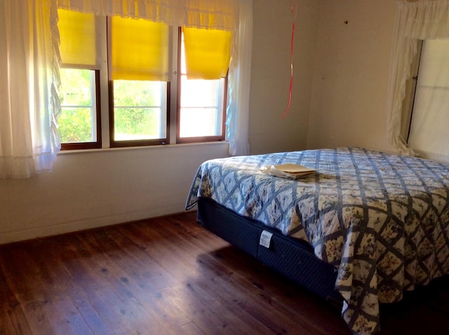 bedroom with dark wood-type flooring