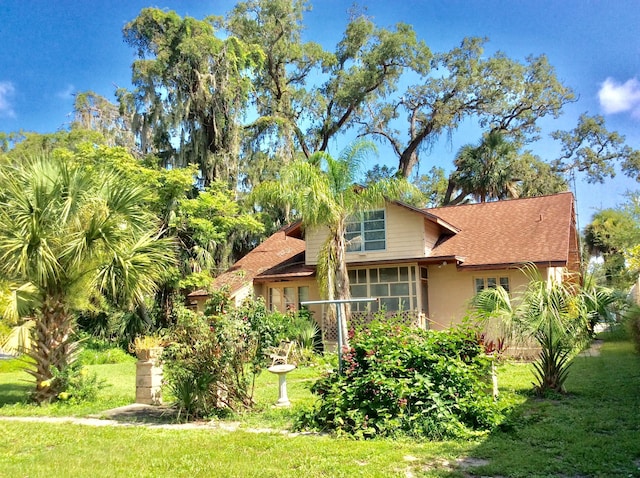 view of front of home with a front yard and a sunroom