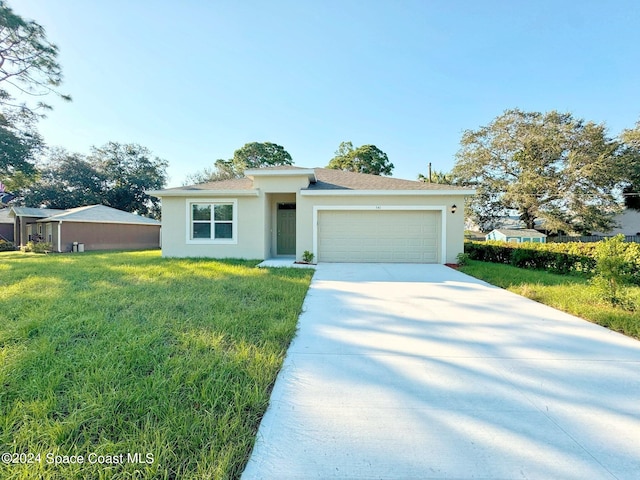 view of front of home with a front yard and a garage