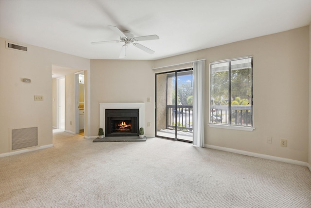 unfurnished living room featuring light carpet and ceiling fan