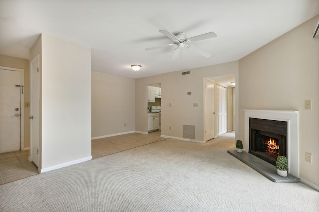 unfurnished living room featuring light colored carpet and ceiling fan