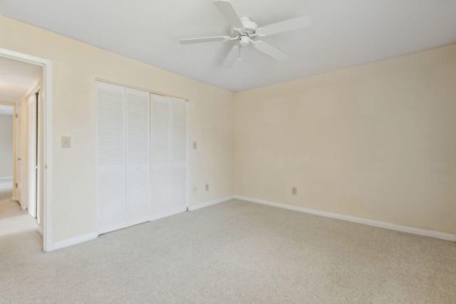 unfurnished bedroom featuring light colored carpet, a closet, and ceiling fan