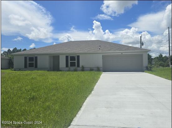 ranch-style home with a garage and a front yard