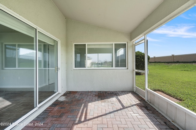 unfurnished sunroom featuring a wealth of natural light and vaulted ceiling