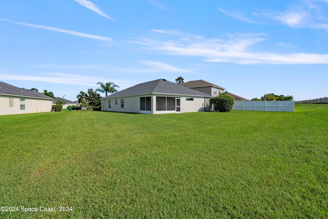 back of house with fence and a lawn