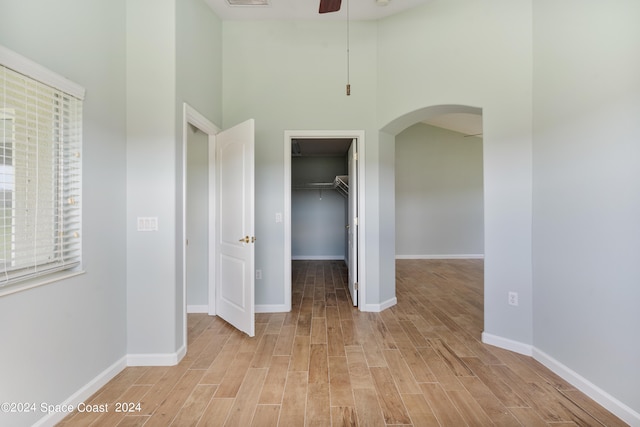 interior space featuring a high ceiling, ceiling fan, and light hardwood / wood-style floors