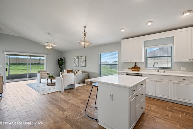 kitchen with a kitchen island, pendant lighting, light hardwood / wood-style flooring, and white cabinetry