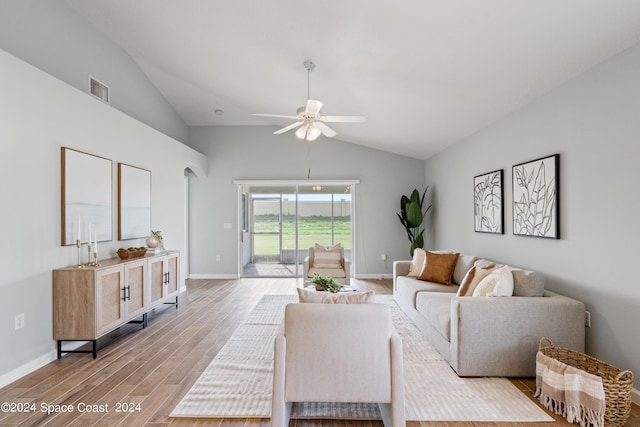 living room with ceiling fan, vaulted ceiling, and light hardwood / wood-style flooring