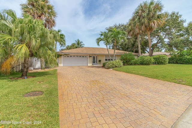 view of front of property featuring a front yard and a garage