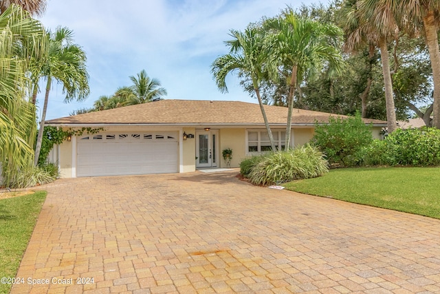 ranch-style home featuring a front lawn and a garage