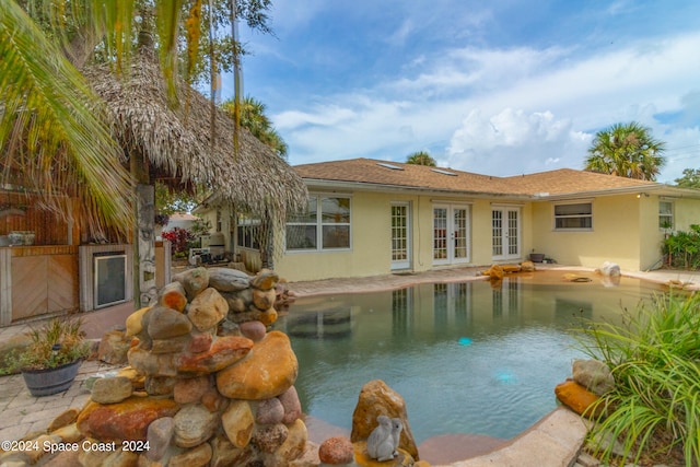 view of swimming pool with french doors and a patio area