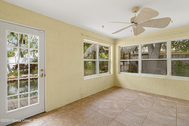 unfurnished sunroom with ceiling fan