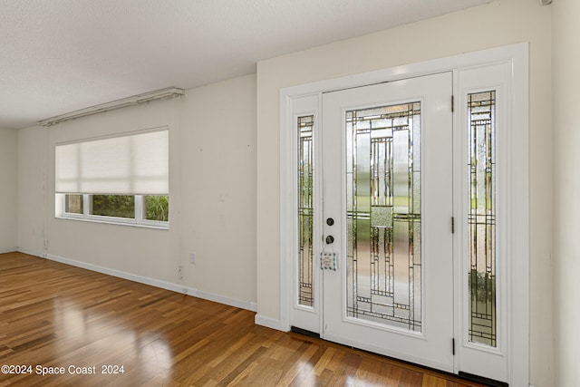 foyer entrance with a textured ceiling and hardwood / wood-style floors