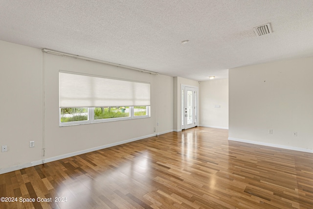 empty room featuring hardwood / wood-style floors and a textured ceiling