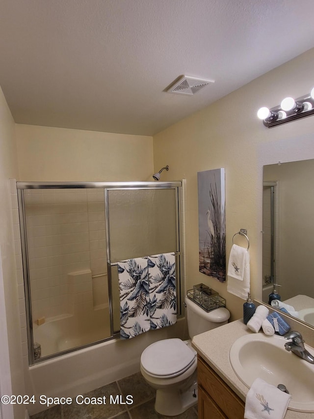 full bathroom featuring vanity, enclosed tub / shower combo, toilet, and tile patterned flooring