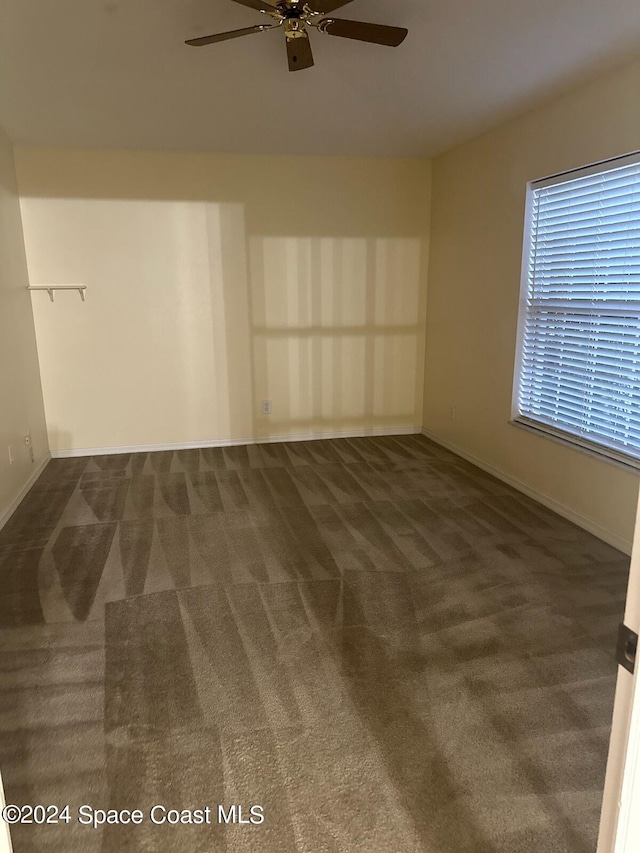 carpeted spare room with ceiling fan