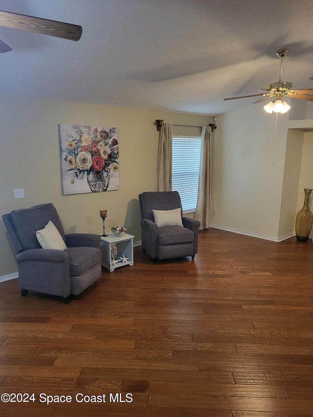 sitting room with dark hardwood / wood-style floors, a textured ceiling, and ceiling fan