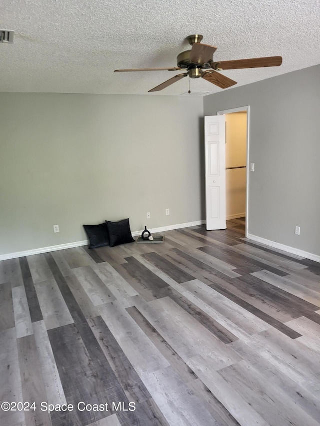 spare room featuring ceiling fan, a textured ceiling, and wood-type flooring