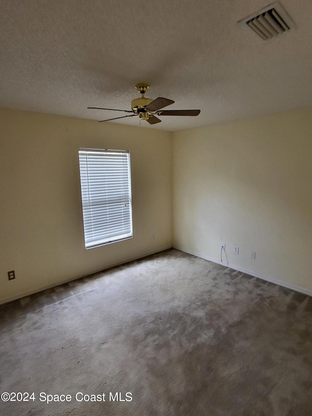 carpeted empty room with a textured ceiling and ceiling fan