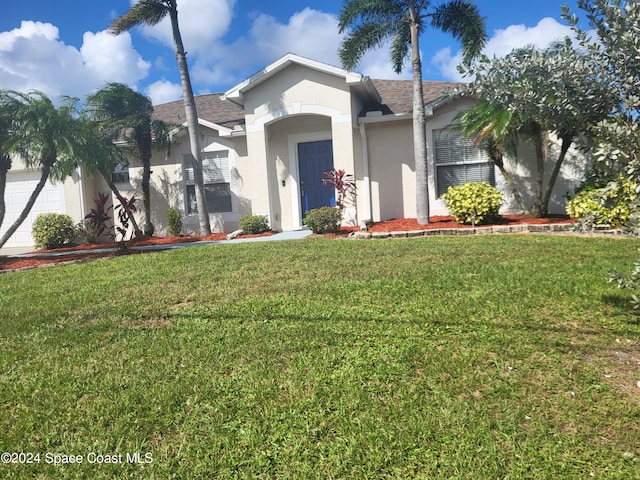 single story home featuring a front lawn and a garage