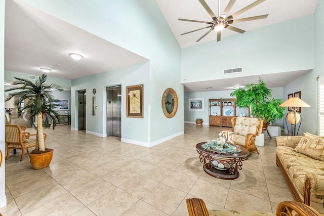 tiled living room with a towering ceiling, elevator, and ceiling fan