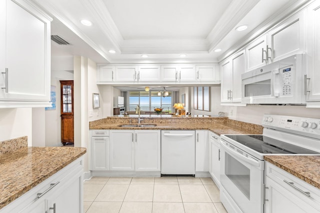 kitchen with white appliances, white cabinets, a tray ceiling, sink, and ornamental molding