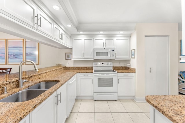 kitchen with white appliances, sink, light stone counters, light tile patterned floors, and white cabinetry