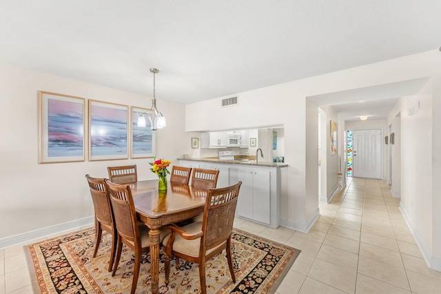 dining room with a notable chandelier, sink, and light tile patterned flooring