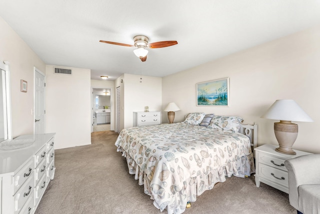 bedroom with ensuite bathroom, ceiling fan, and light colored carpet