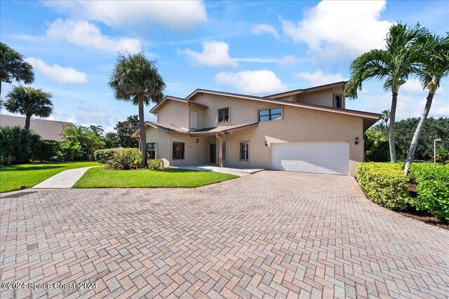 front facade with a garage and a front yard