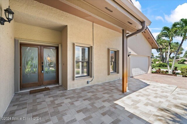 view of patio with a garage and french doors