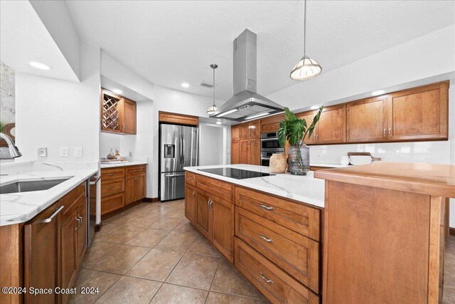 kitchen with sink, light stone countertops, hanging light fixtures, island exhaust hood, and appliances with stainless steel finishes