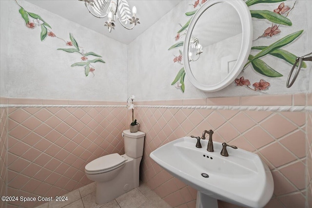 bathroom with tile walls, toilet, sink, and tile patterned flooring