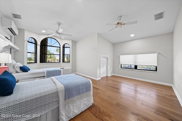 bedroom featuring vaulted ceiling, hardwood / wood-style flooring, a wall unit AC, and ceiling fan