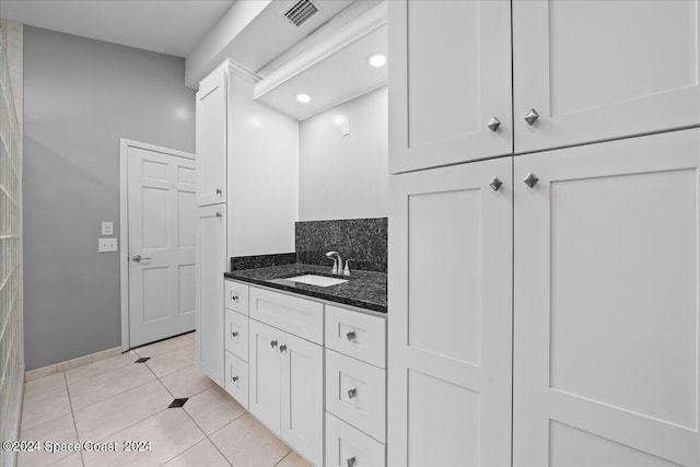 bathroom featuring tile patterned flooring, decorative backsplash, and vanity