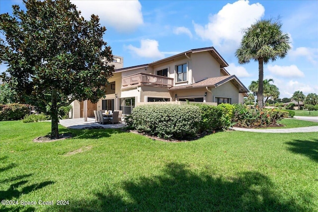 exterior space featuring a balcony and a front yard