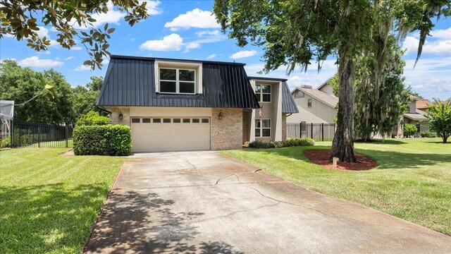 view of front of house with a garage and a front lawn