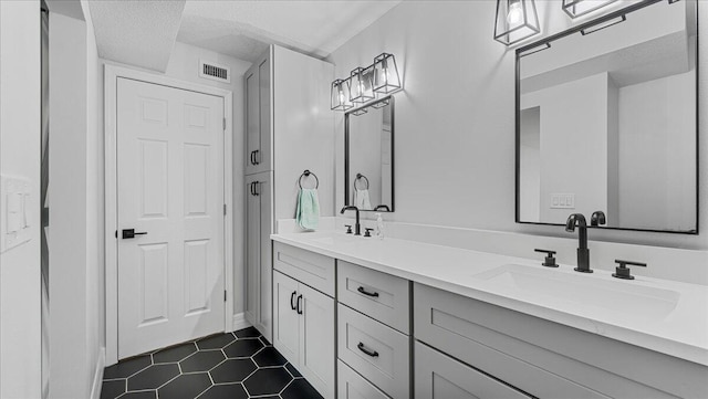 bathroom featuring tile patterned flooring, vanity, and a textured ceiling