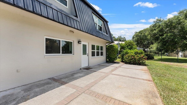 view of property exterior with a patio area and a lawn