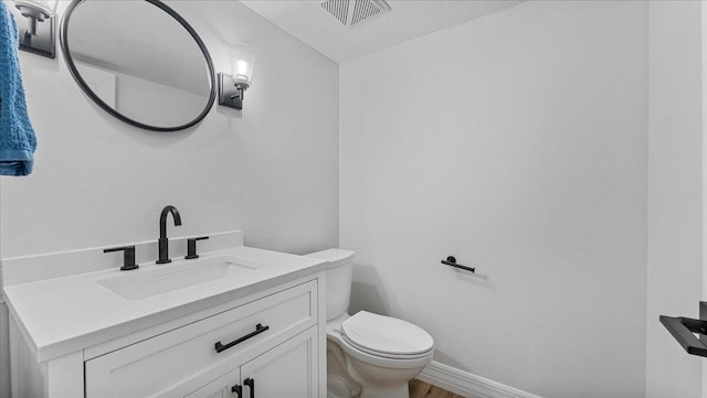 bathroom featuring hardwood / wood-style flooring, vanity, toilet, and a textured ceiling