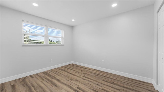 unfurnished room with hardwood / wood-style flooring